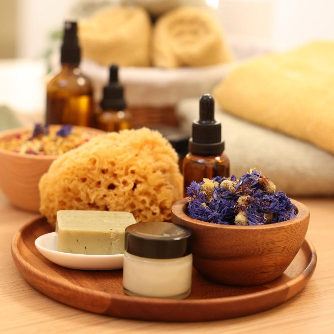 Assorted natural skincare products on a wooden tray with a blurred background